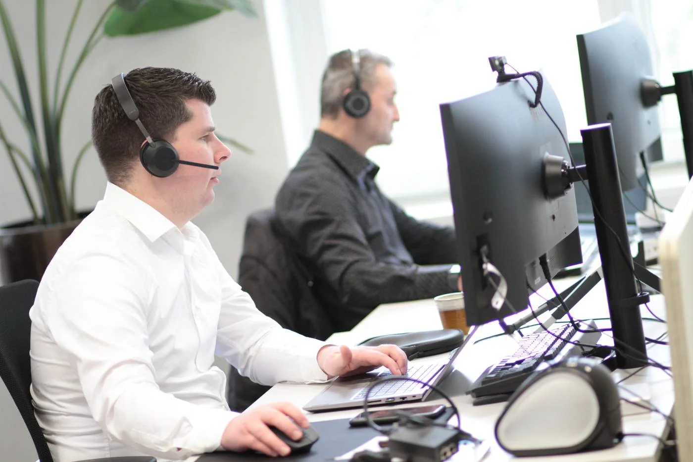 Servicedeskmedewerkers van DACON met headset aan het werk